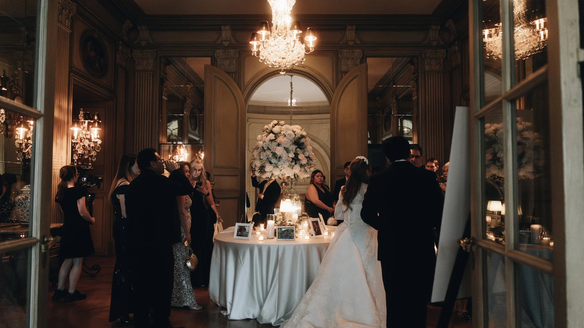 The couple at their table, seen from the next room through the doorway