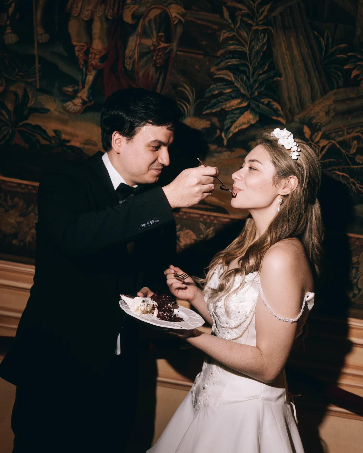 The groom feeding the bride a forkful of cake