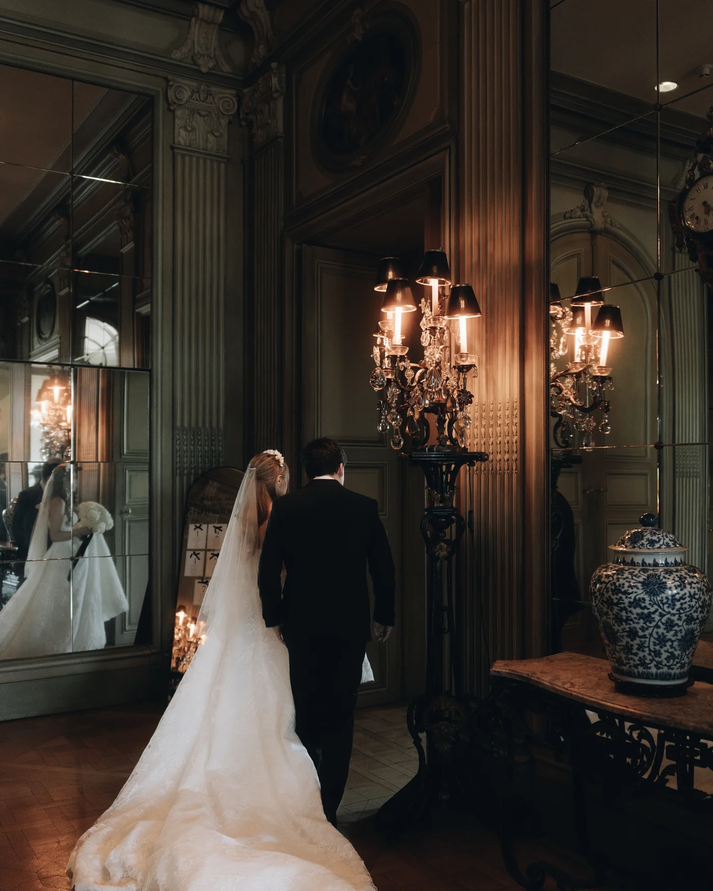 The bride walking through the panelled hall in a long train