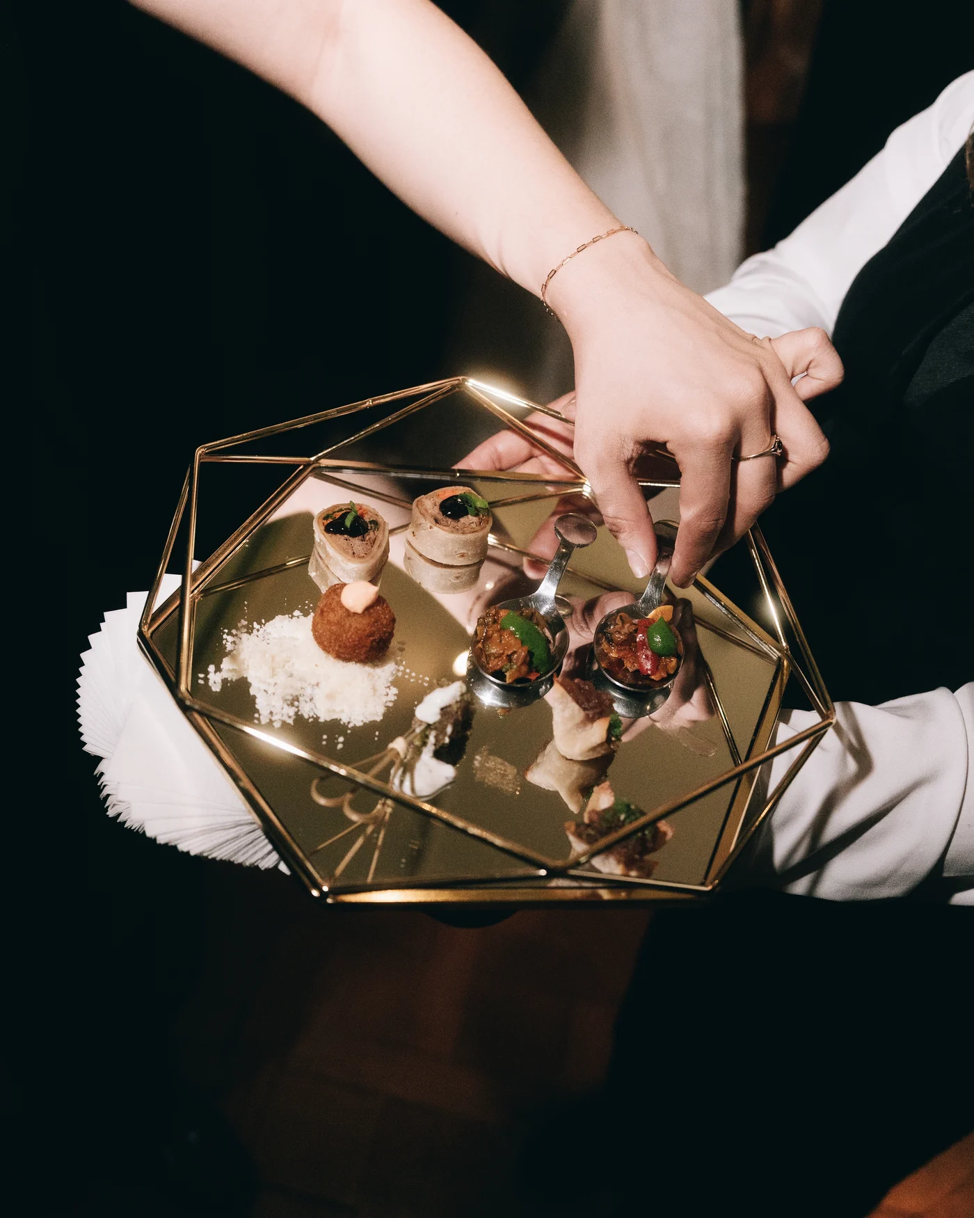 Hands holding a small glass and brass box of rings