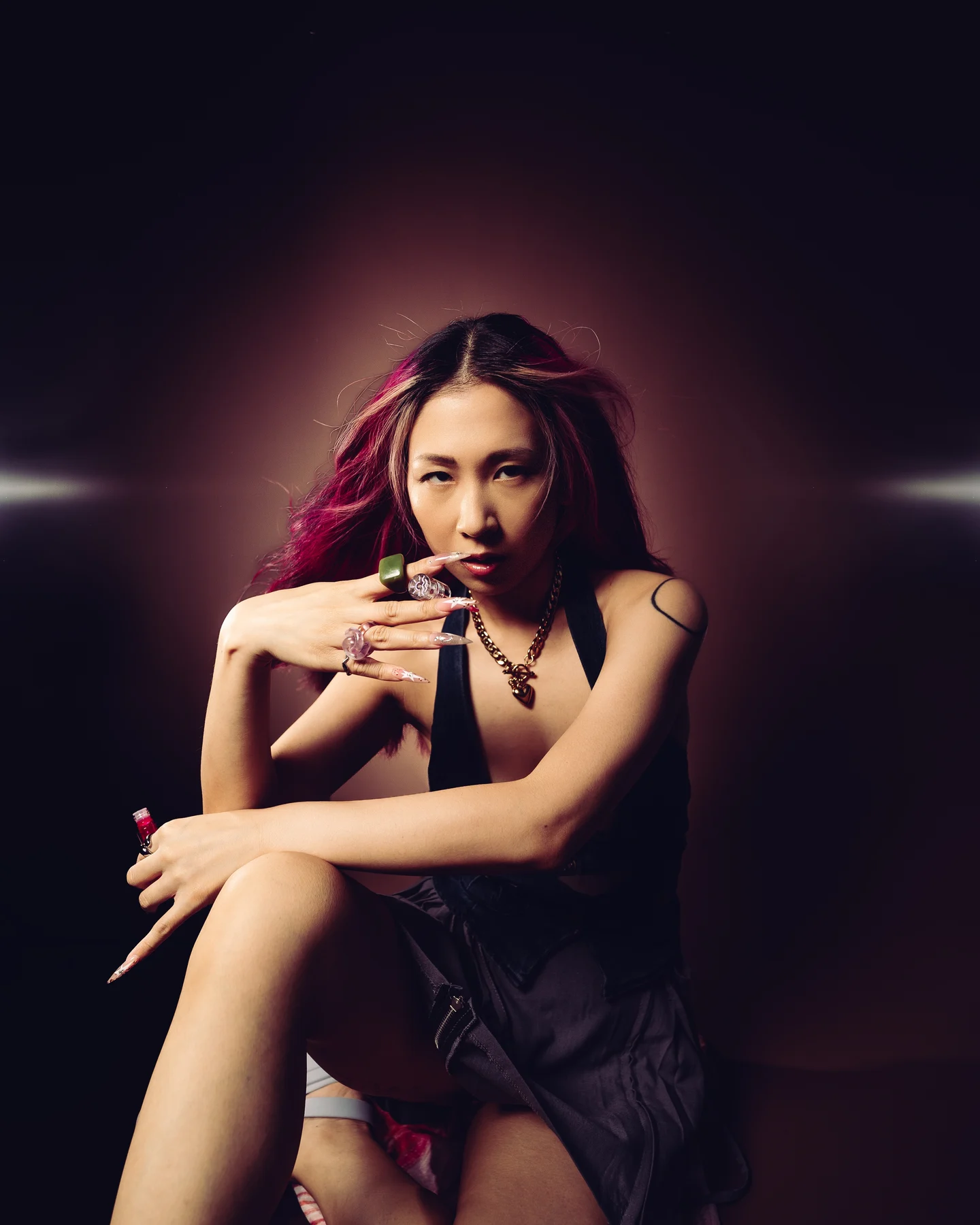 Portrait in a black halter top, arms crossed, rings catching the light