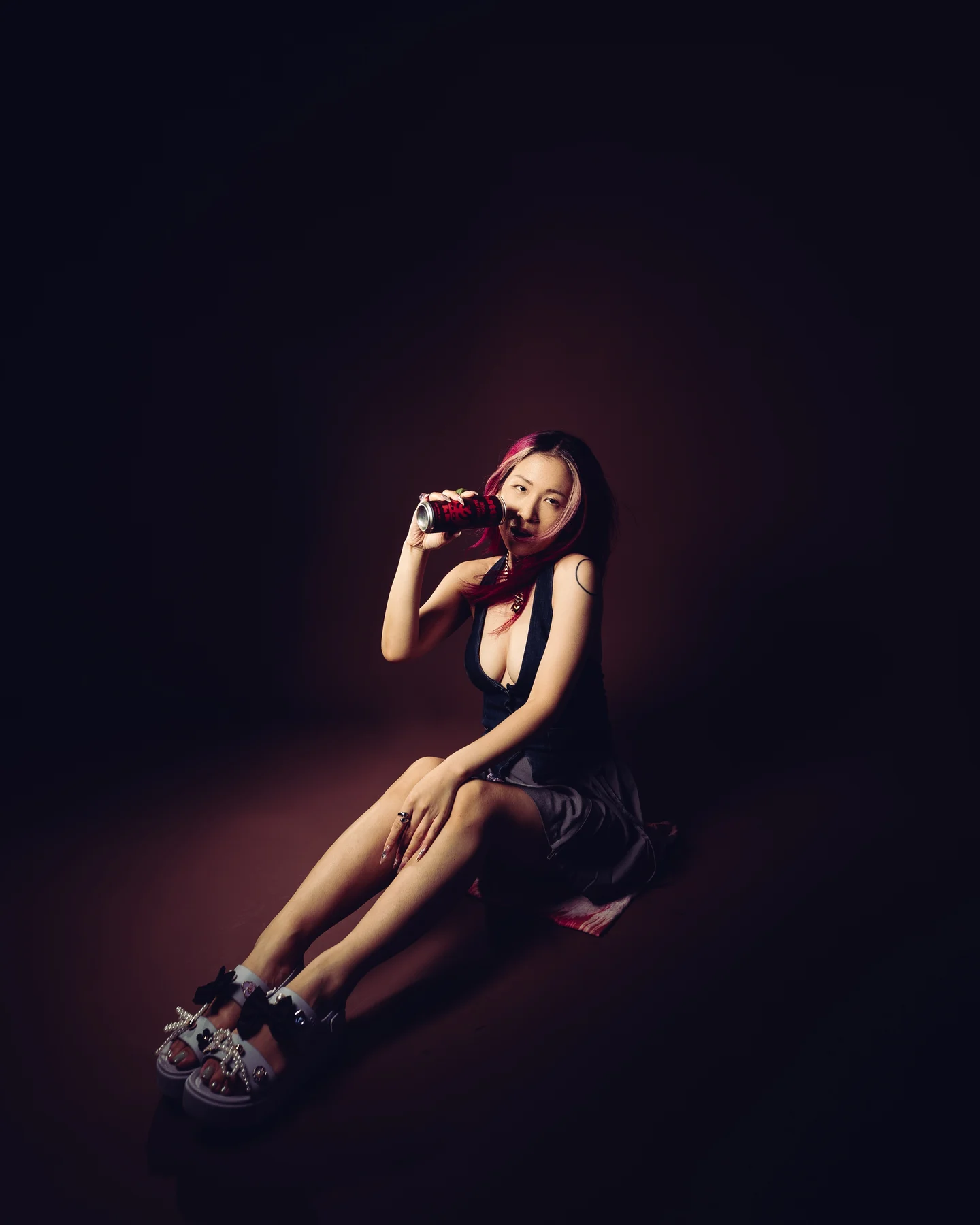 Crouched on the studio floor in platform sneakers, hands in her hair