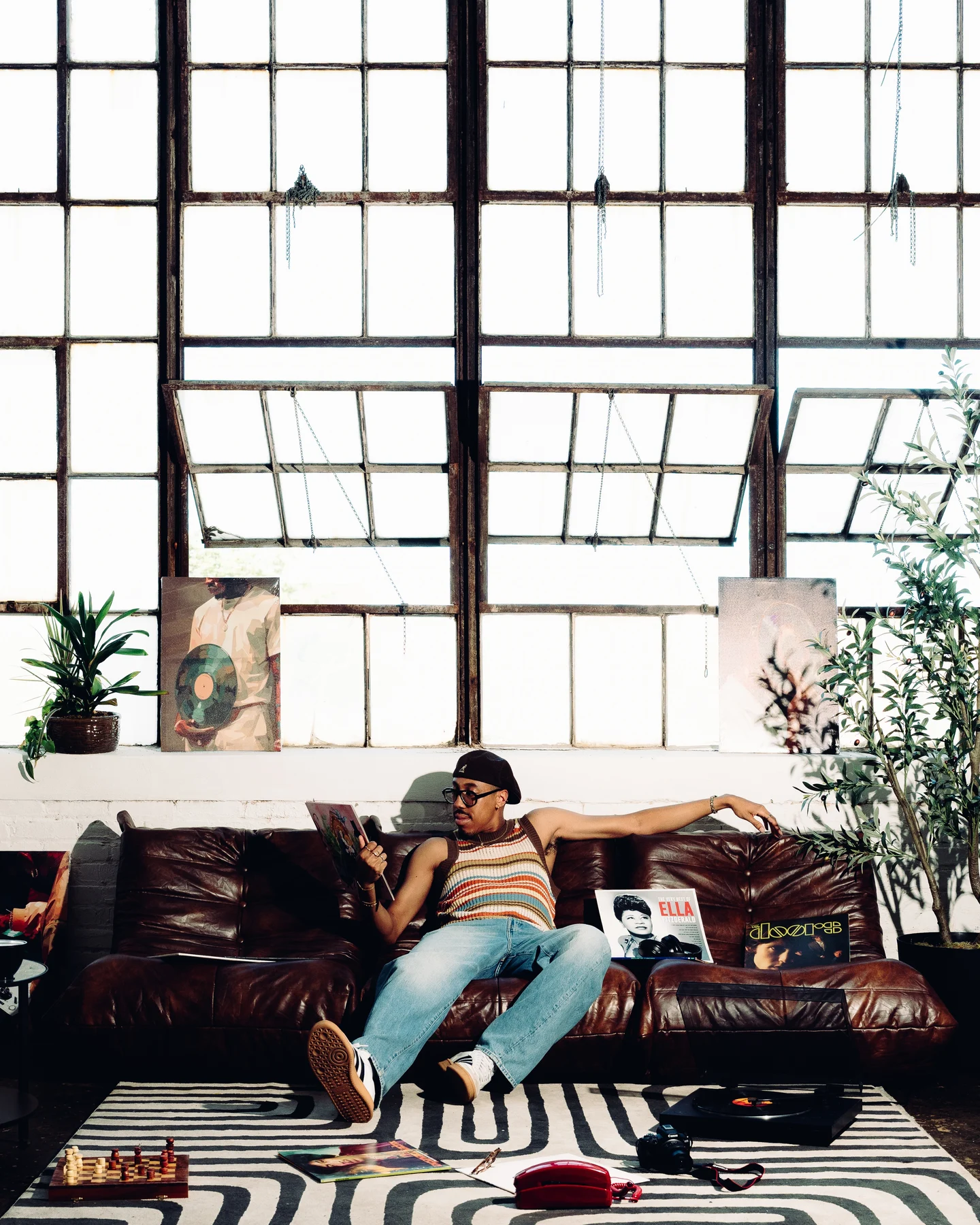 Kyle lying across the leather sofa under the loft windows, a magazine open