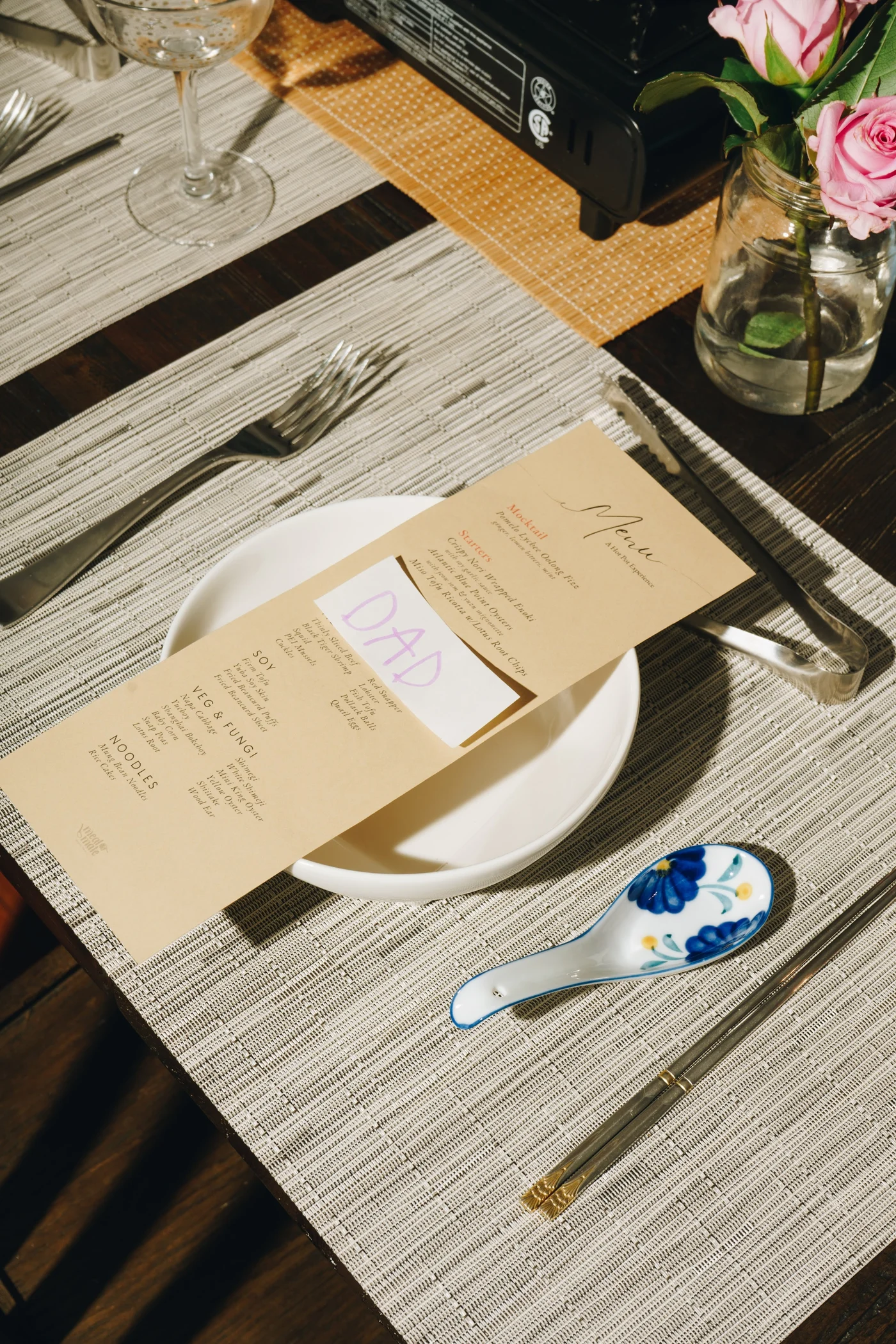 A printed menu propped on a white plate, a handwritten DAD card tucked into it