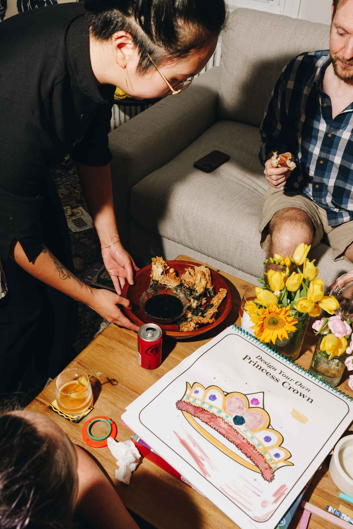 A chef sets down a plate of fritters beside a princess crown coloring page