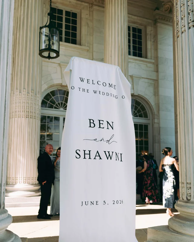 A draped fabric sign welcomes guests to the wedding of Ben and Shawni beneath a hanging lantern