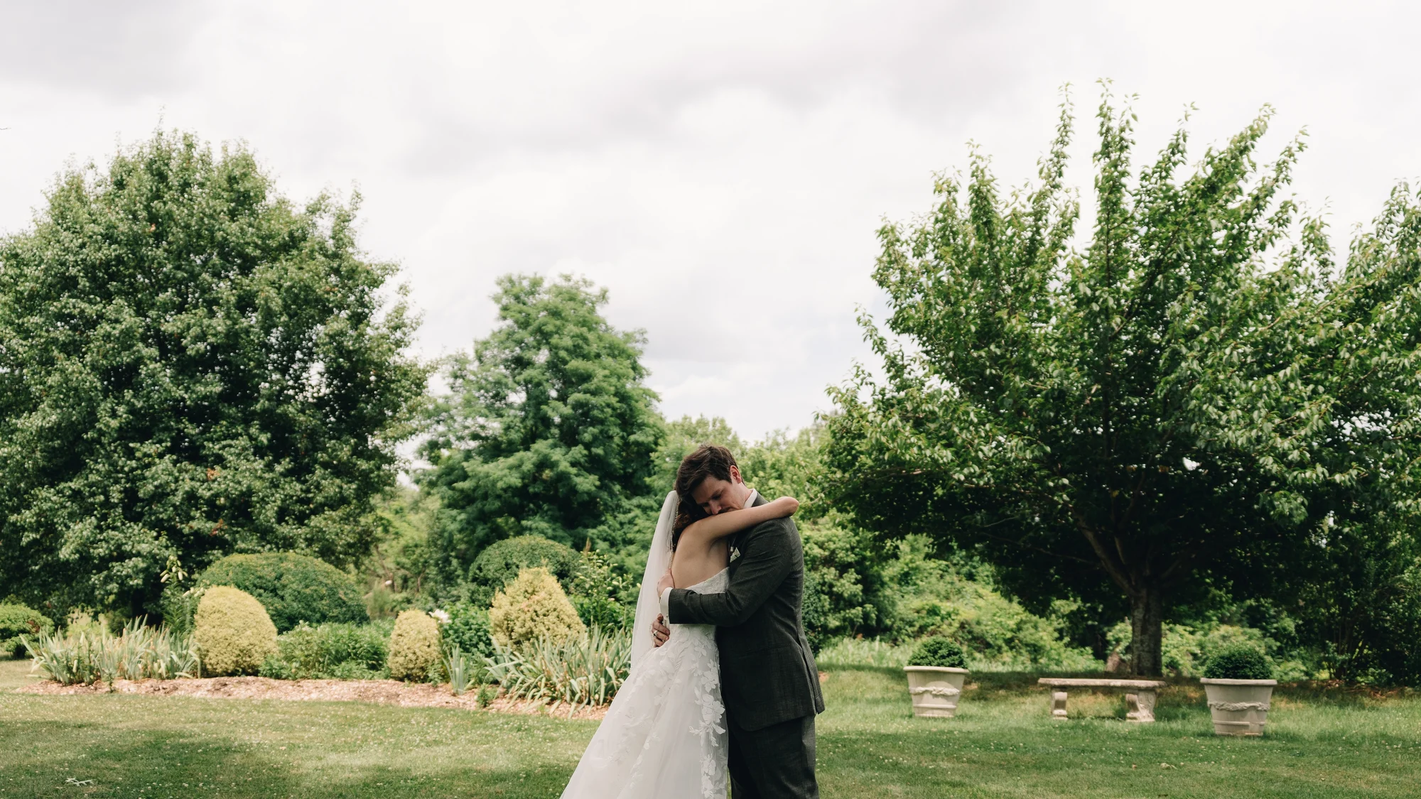 The bride and groom holding each other on the lawn after the first look
