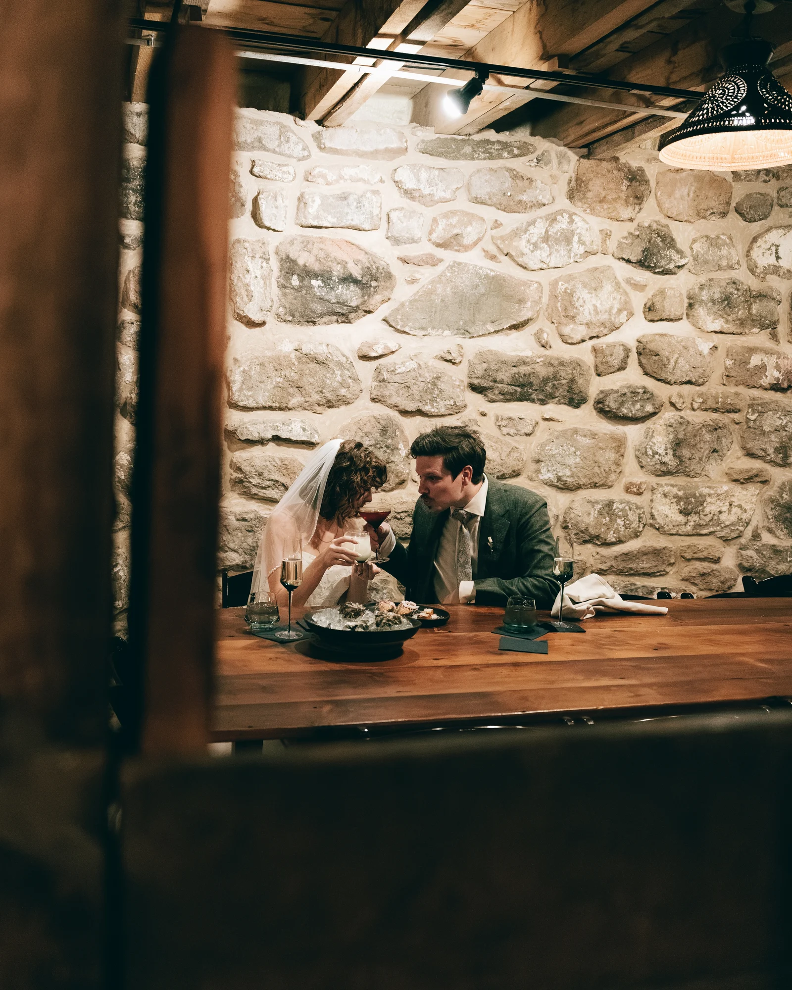 The bride and groom eating together alone in a stone walled room