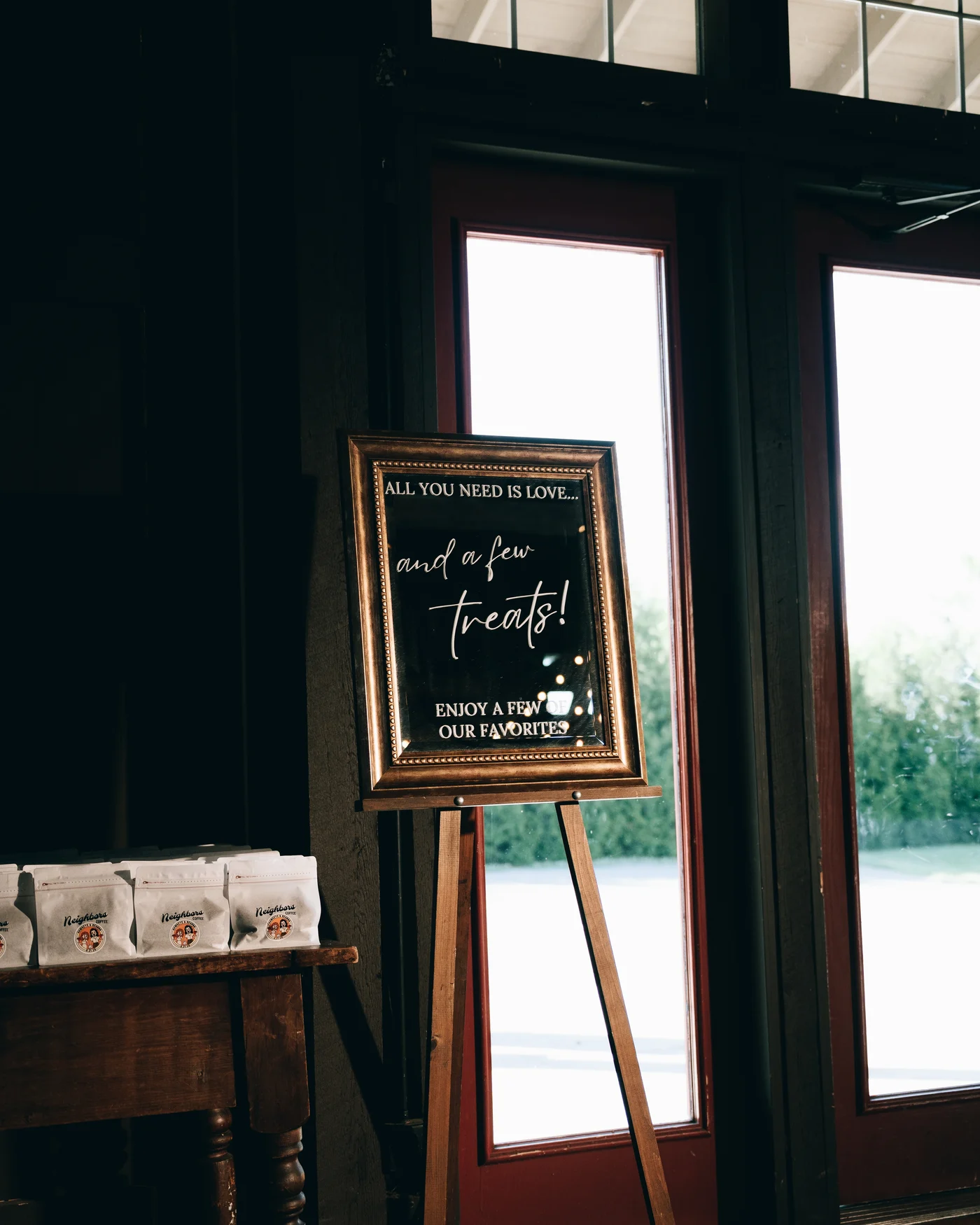 A hand lettered welcome sign on an easel beside the barn window