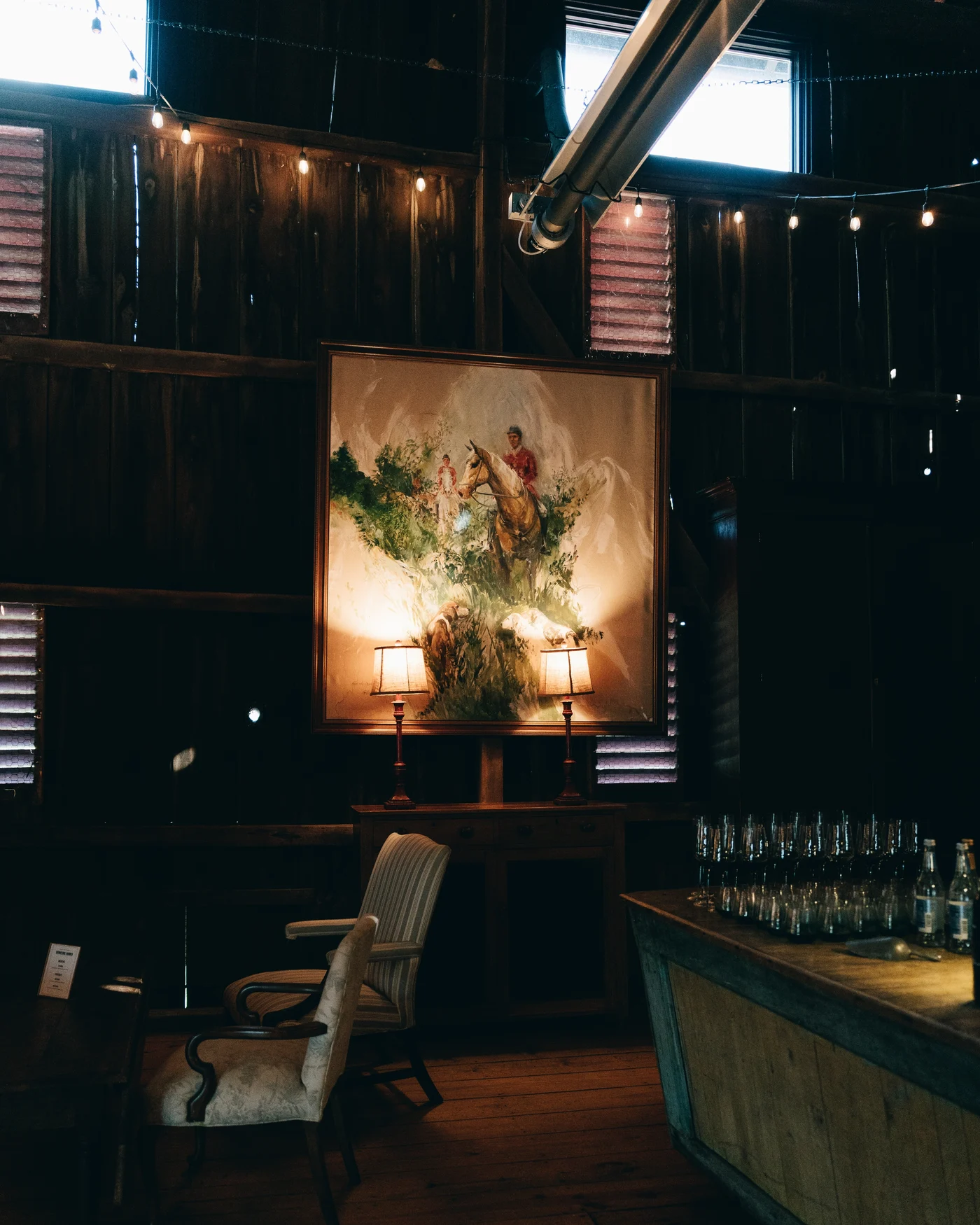 The bar in the barn, bottles lit by lamplight